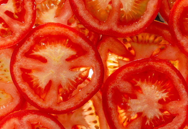 макро помидоры, ломтики помидоров. натуральный фон с ломтиками помидора. - carotene healthy eating macro close up стоковые фото и изображения