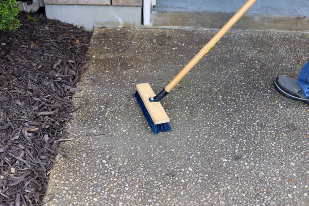 A man cleaning a driveway with a brush stock photo