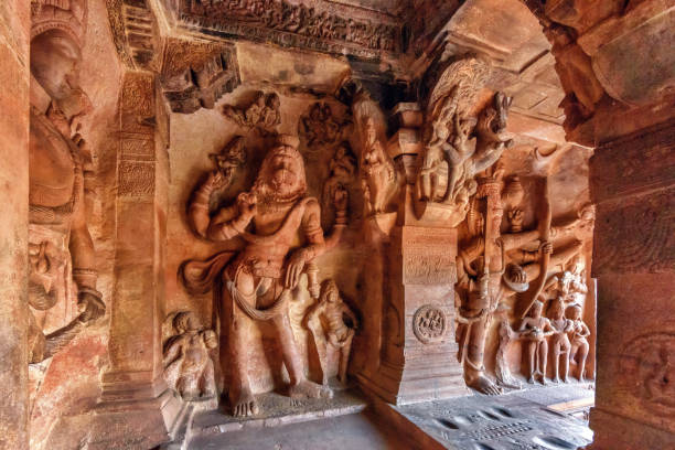 Badami, Karnataka, India - November 7, 2013: Cave temples above Agasthya Lake. Closeup of brownish stone statue of Vishnu seated on serpent Sesha in cave 3.