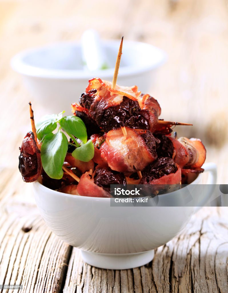 Prunes wrapped  in rashers of bacon - detail Bacon Stock Photo