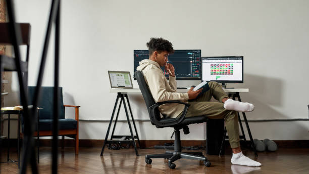 African American man expert trade online on computer while studying stock photo