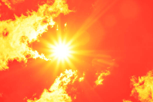 istock Bright sun with beautiful beams in the sky with clouds (toned in red) 1338903087