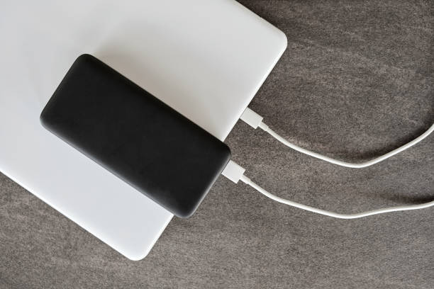 istock Power bank charges a laptop via USB type C cable on gray stone background 1338905647