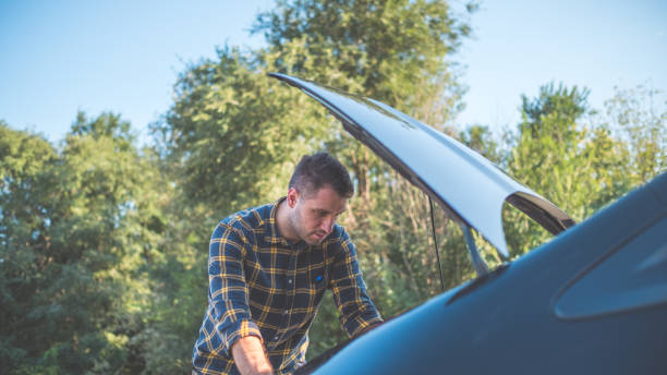 istock man looking under the bonnet of broken car 1338906894