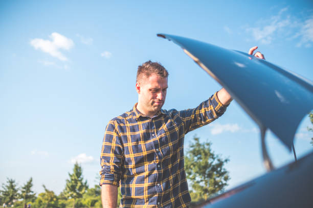 istock man with broken car on the road 1338907001