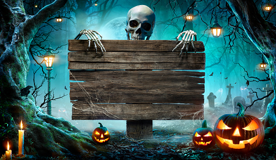 Tarjeta de fiesta de Halloween - Calabazas y esqueleto en el cementerio por la noche con tabla de madera photo