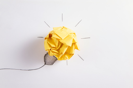 Ideas with yellow paper crumpled ball  on white paper