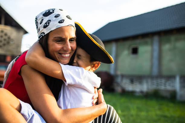 Portrait of cute little baby boy in cowboy hat holding by his mother