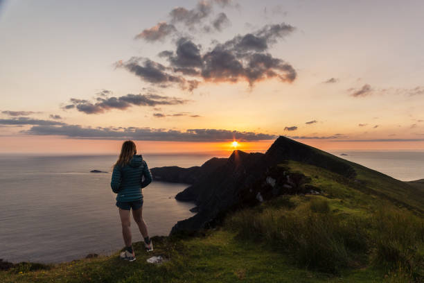 donna che guarda la vista delle scogliere di croaghaun sull'isola di achill in irlanda - county mayo ireland foto e immagini stock
