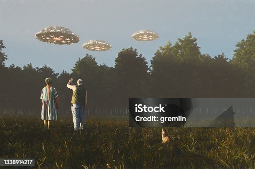 istock Senior couple waving at flying UFOs 1338914217