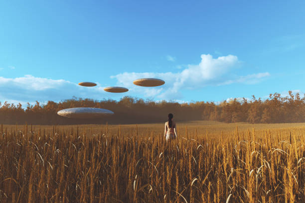 kobieta idąca w kierunku ufo na polu pszenicy - ufo landing zdjęcia i obrazy z banku zdjęć