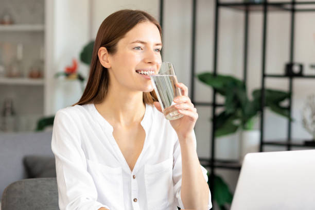 istock Smiling caucasian business woman working using laptop, resting and drinking refreshing water for more effective work, remote work at home 1338914339