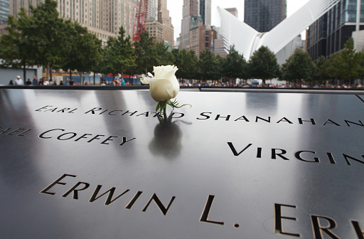 New York, New York / U.S.A. - September 28 2019: An image of victims of the 9/11 terrorist attack on the World Trade Center at the 9/11 memorial. There is a single white rose on one of the names.