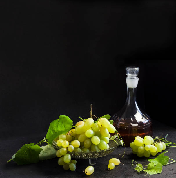 istock Fresh ripe grapes and decanter with grape juice on black background 1338916320