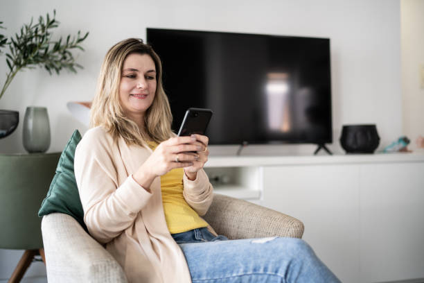 istock Woman using smartphone at home 1338918133
