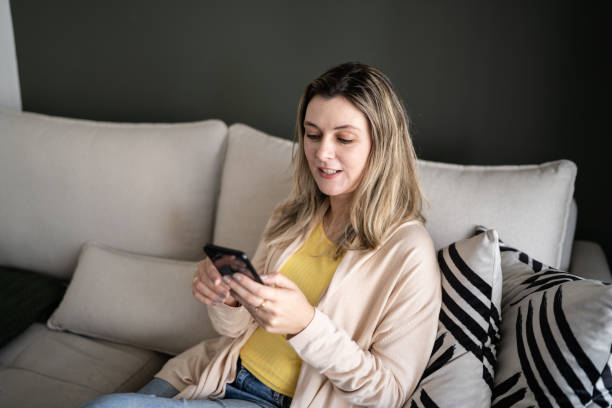 istock Woman using smartphone at home 1338918426