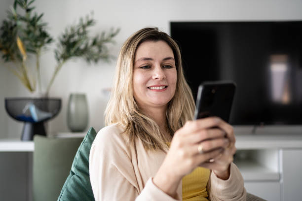 istock Woman using smartphone at home 1338918440