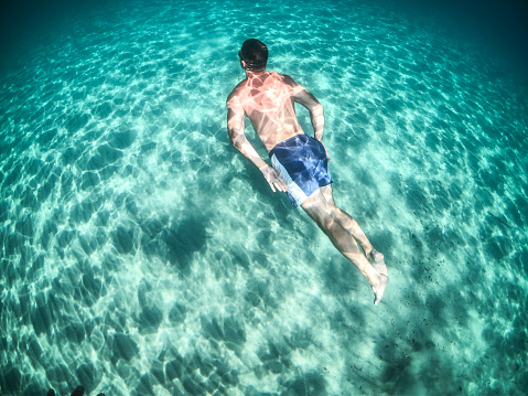 One man, a young man diving into the sea. Photographed with a GoPro camera in a DOME case.