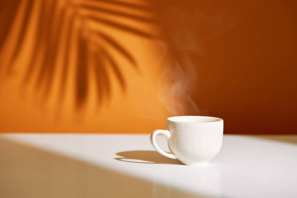 istock Close-up of coffee cup on table at direct sunlight 1338919523