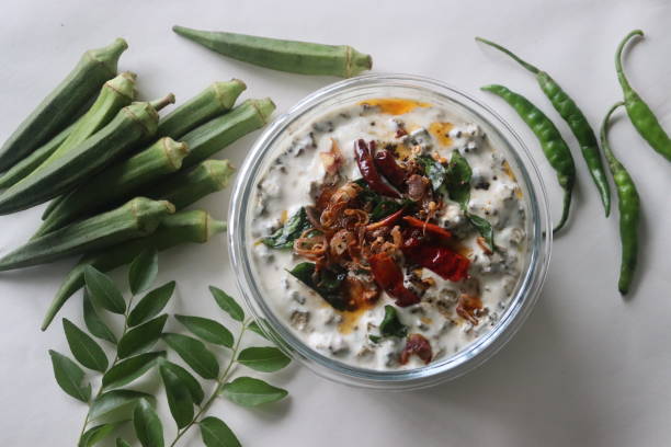 Ladies finger raita or Vendaka kichadi. A yogurt based side dish for traditional Kerala meals. Crisp fried ladies finger in thick and creamy yogurt Ladies finger raita or Vendaka kichadi. A yogurt based side dish for traditional Kerala meals. Crisp fried ladies finger in thick and creamy yogurt. Shot on white background. karahi stock pictures, royalty-free photos & images