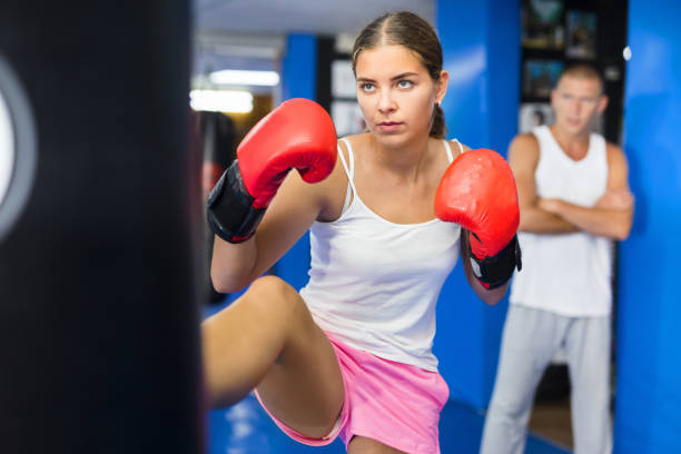 istock Young female practicing kicks with punching bag 1338920817