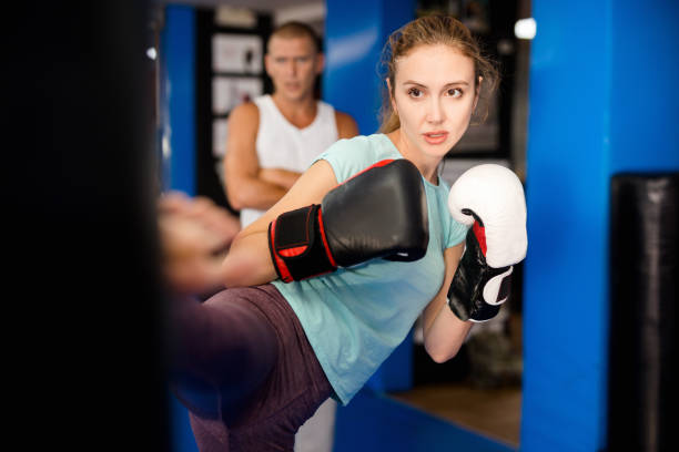istock Young female practicing kicks with punching bag 1338920818