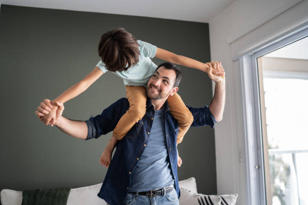 istock Father playing with son carrying him over the shoulder at home 1338921070