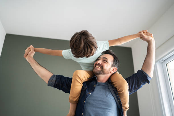 istock Father playing with son carrying him over the shoulder at home 1338921176
