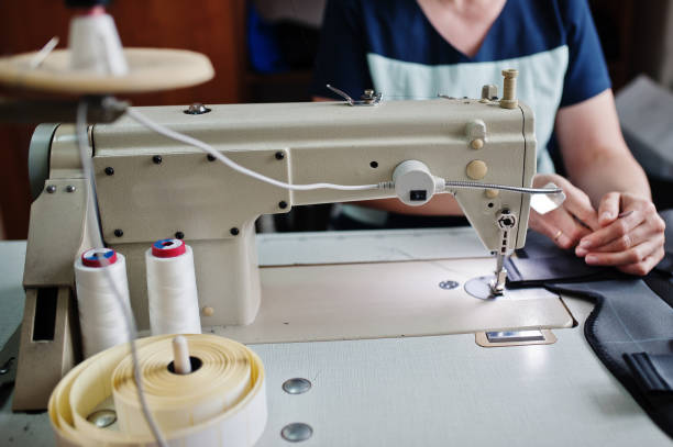 istock Female hands stitching fabric on professional manufacturing machine at workplace. Sewing process. 1338921268