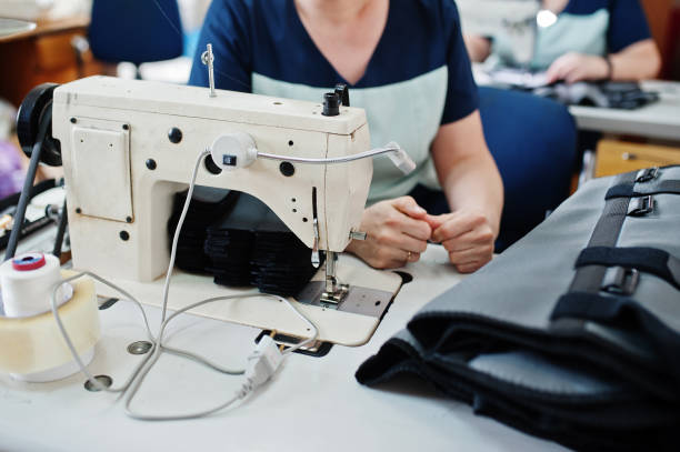 istock Female hands stitching fabric on professional manufacturing machine at workplace. Sewing process. 1338921292