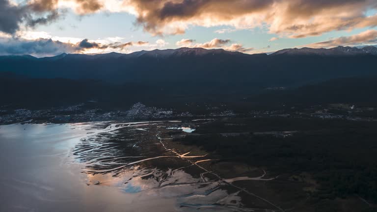 Aerial hyperlapse of Hornopiren with the junction of the White River and the Pacific Ocean at sunset.