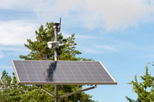 istock Solar powered surveillance camera. Solar panels powering a surveillance camera in a city park against a background of blue sky. Safety and clean energy concept 1338922251