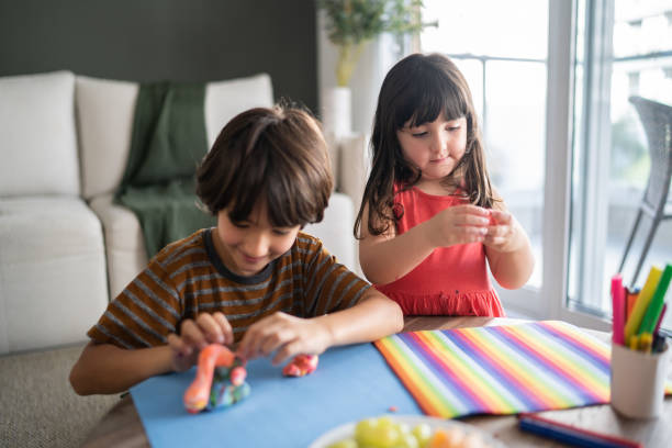 istock Siblings playing with play dough at home 1338922436
