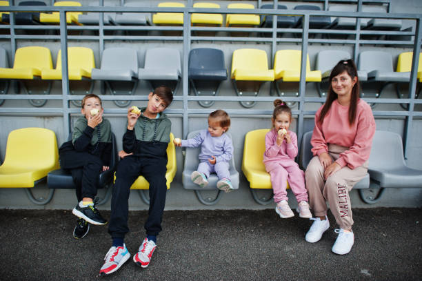 giovane madre elegante con quattro bambini all'aperto. - 12 23 mesi foto e immagini stock