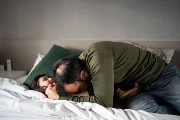 istock Father tickling daughter in bed at home 1338922788