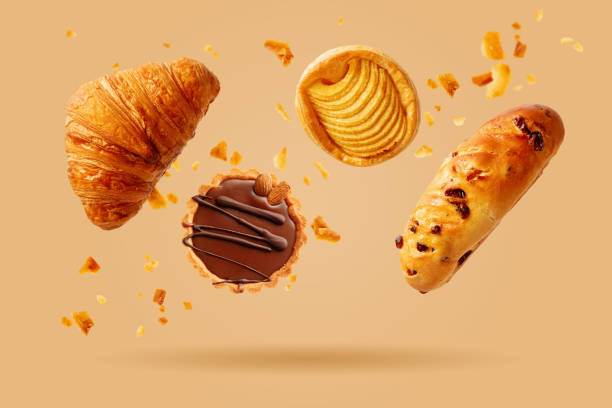 Freshly baked croissant and sweet pastries flying in air. stock photo