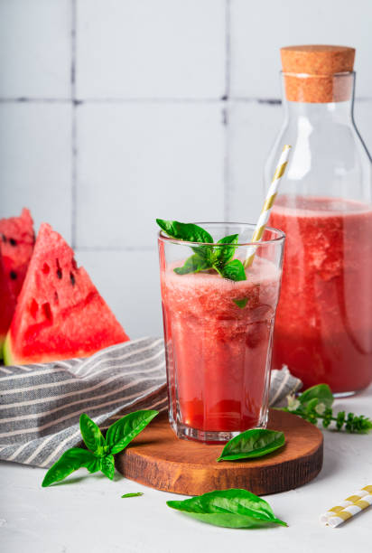 fresh homemade watermelon and basil smoothie in glass on white tile background - watermelon summer melon portion imagens e fotografias de stock