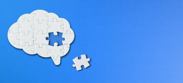 istock Brain shaped white jigsaw puzzle with copy space on blue background, a missing piece of the brain puzzle, mental health and problems with memory 1338927215