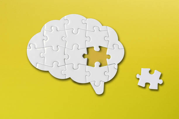 istock Brain shaped white jigsaw puzzle on yellow background, a missing piece of the brain puzzle, mental health and problems with memory 1338927228