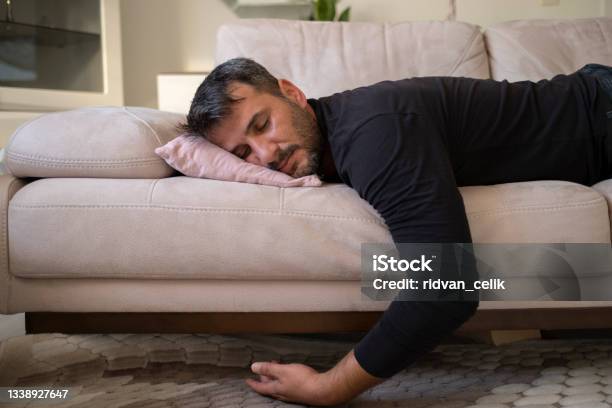Man Flopping Down On Sofa Needs Rest At Home Stock Photo - Download Image Now - Sleeping, Sofa, Men