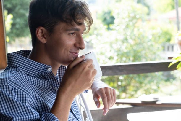 istock Handsome smiling guy with white cup of tea 1338929951