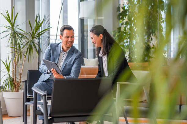 istock Two Asian Entrepreneurs Discussing Business in a Lobby 1338931697