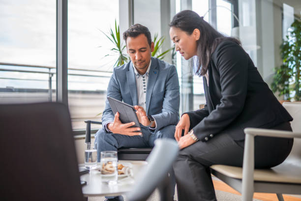 istock Two Asian Entrepreneurs Discussing Business in a Lobby 1338931698