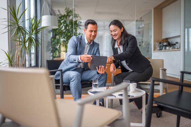 istock Two Asian Entrepreneurs Discussing Business in a Lobby 1338931707