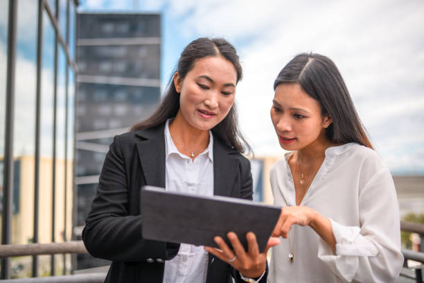 istock Two Asian Businesswomen Using a Digital Tablet 1338931719