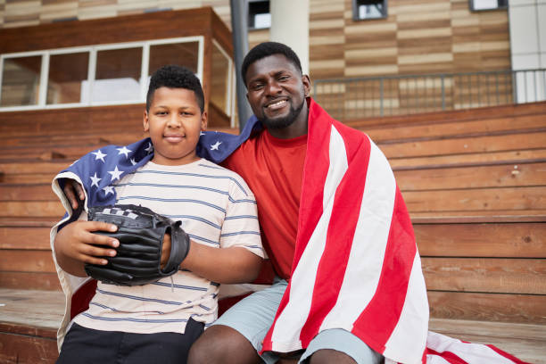 息子を抱きしめる幸せな父 - baseball player american flag sport men ストックフォトと画像