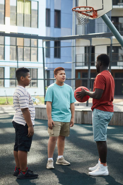 istock Father With Basketball Talking To Boys 1338935602