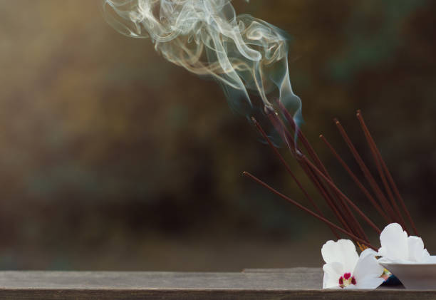 istock Many incense sticks were lit to perform Buddhist rituals Smoke from large quantities of incense and white flowers for Buddhist rituals, religious ceremonies in the open air. Copy space. 1338936003