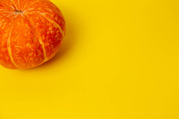 istock Beautiful round pumpkins on a bright orange background 1338939732