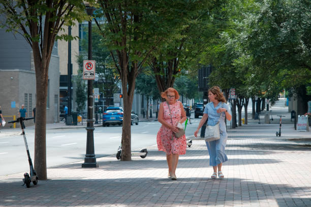 modne kobiety chodzące i rozmawiające w środowisku miejskim - south carolina zdjęcia i obrazy z banku zdjęć